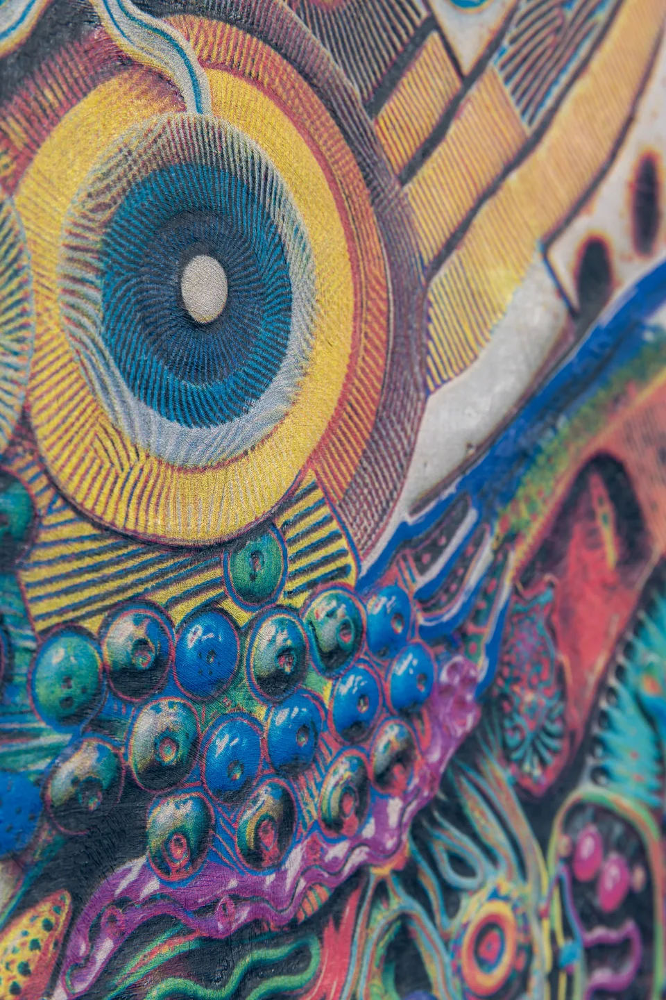 Angled close-up of a circular blue form and the textured painted surface.