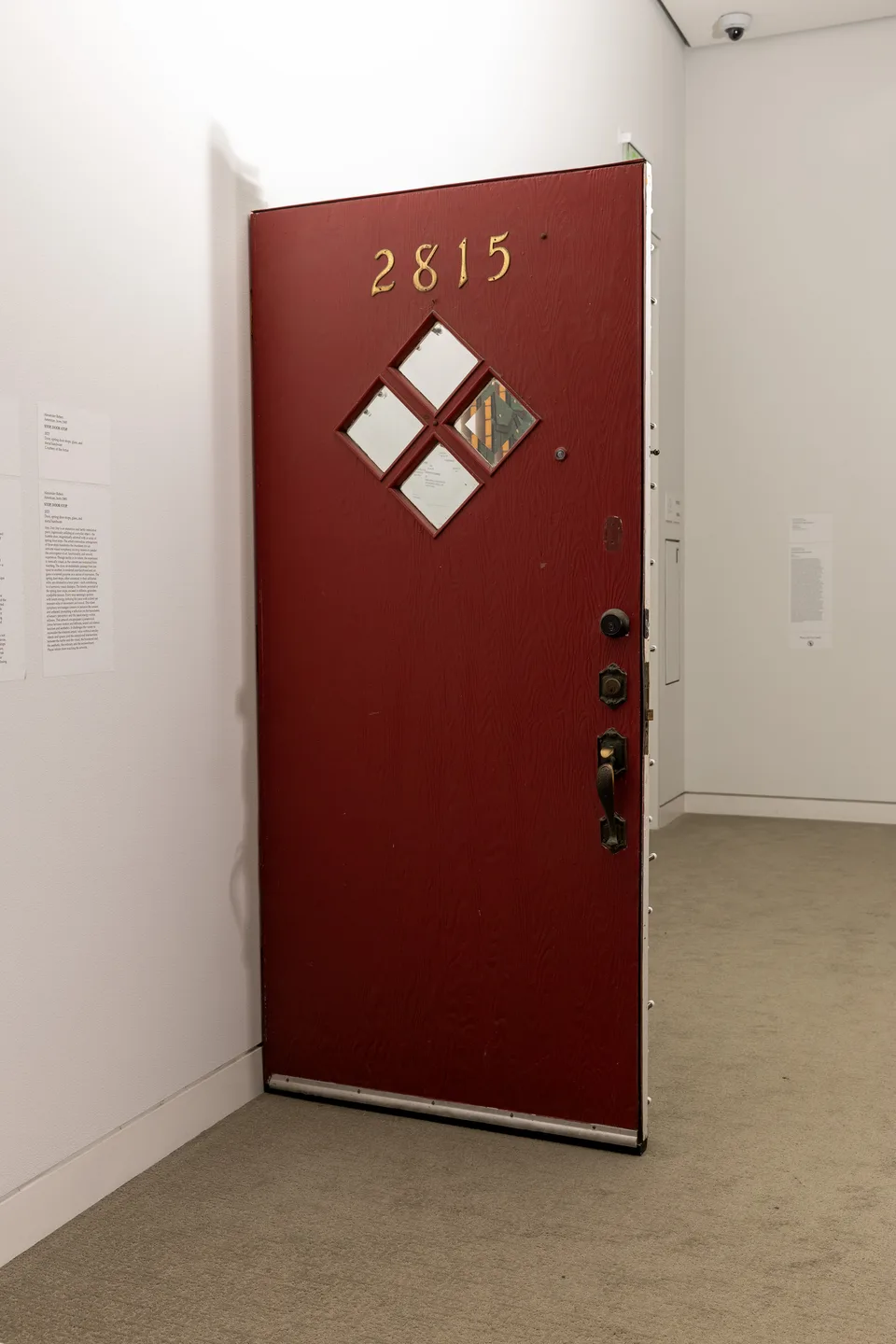 The red reverse of a freestanding door has four diamond-shaped windows and the number 2815.