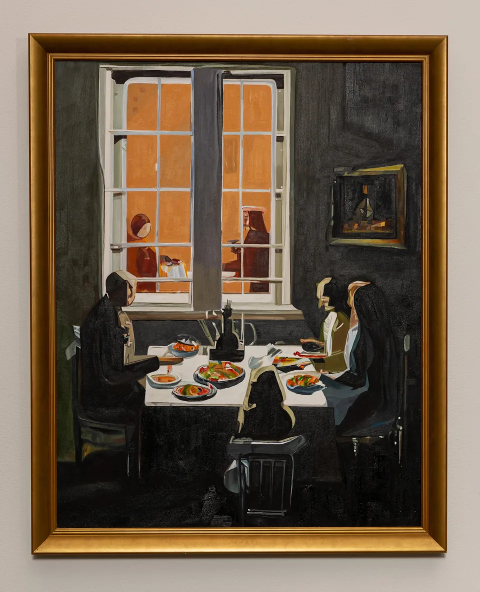 A gold-framed painting depicts figures seated around a dining table in front of an orange-lit window.