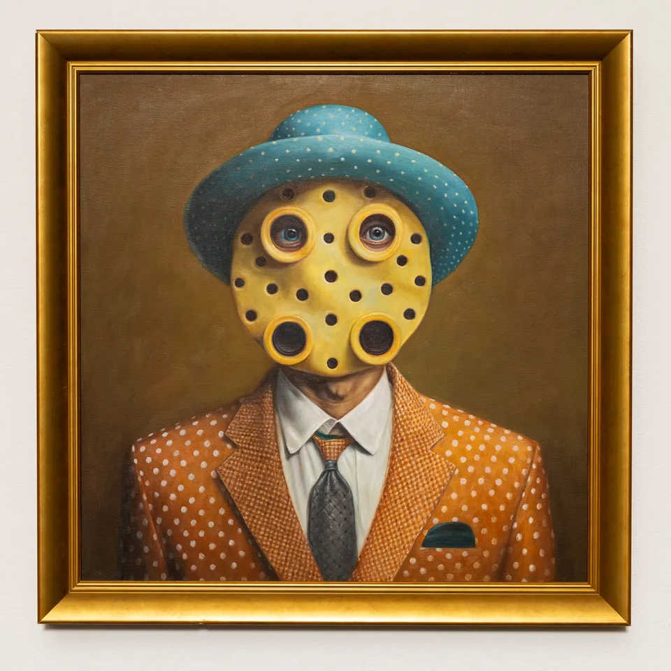 Full framed portrait of a figure with a yellow perforated face, blue hat, and orange patterned suit.