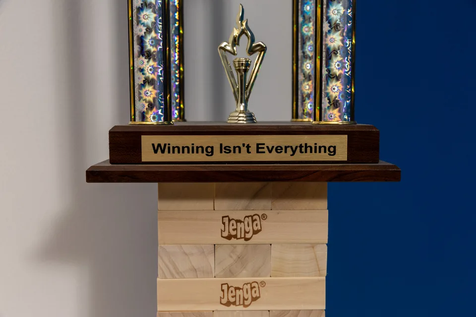 Close detail of the trophy base, its engraved plate, and the stacked wooden blocks.