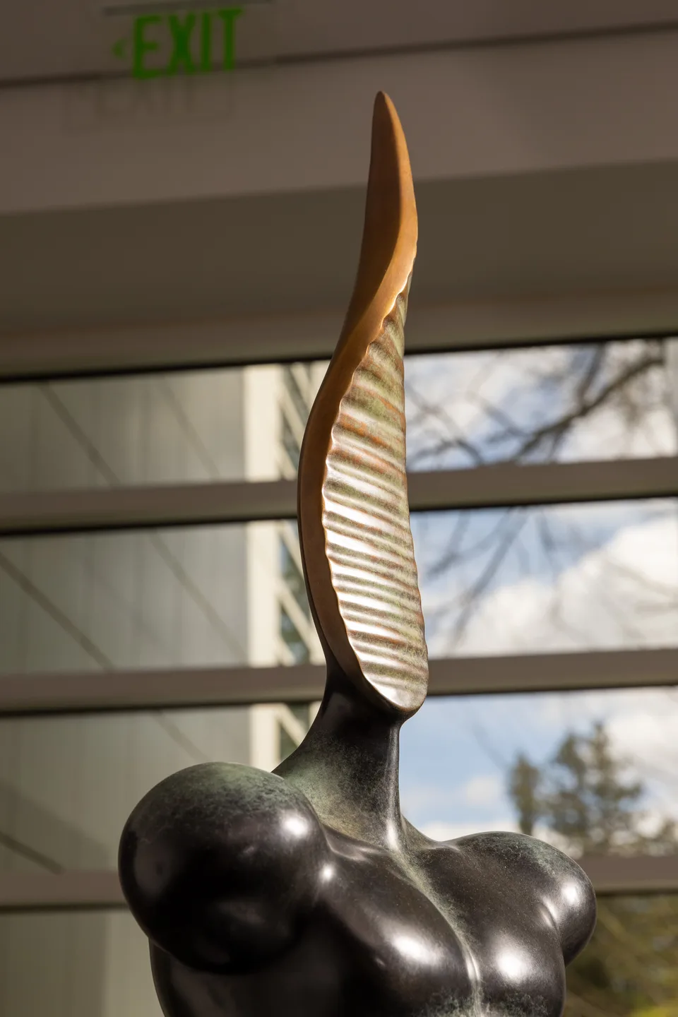 Close-up of the tall blade-like projection rising from the bronze bust.