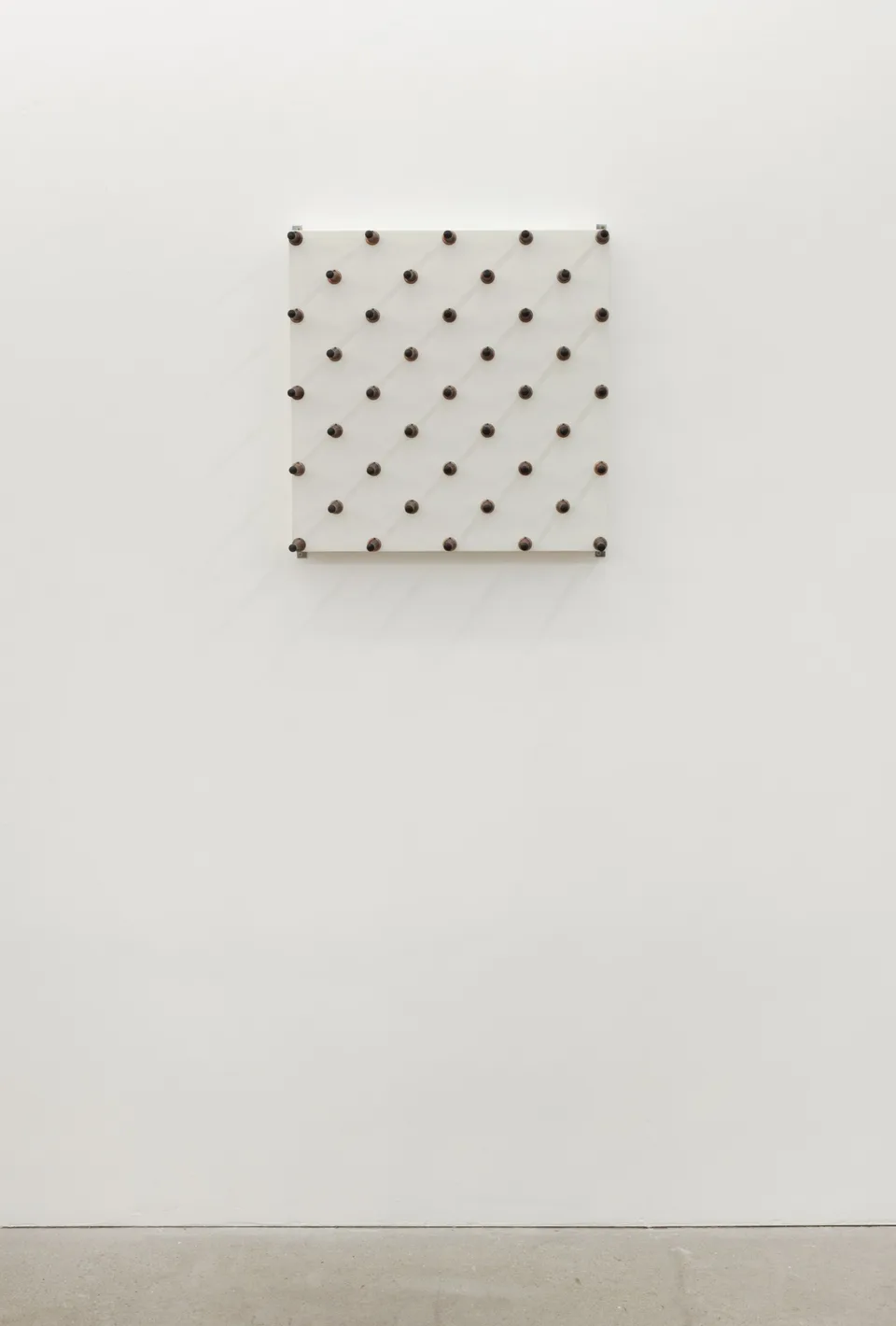 A panel of spring door stops shown against a gallery wall