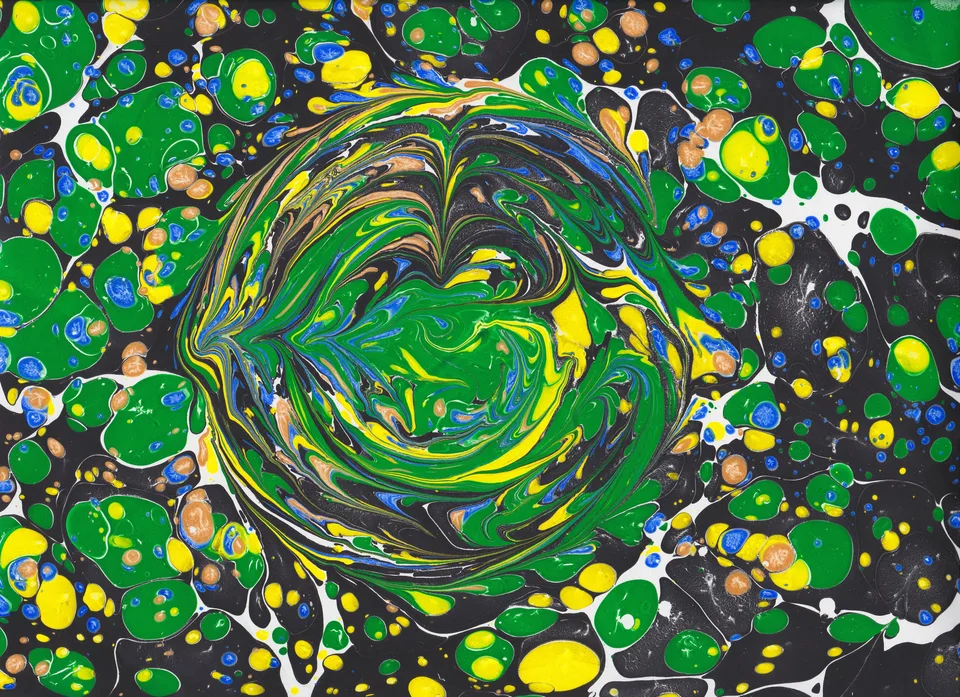 Green and yellow swirls surrounded by round droplets in a marbled composition