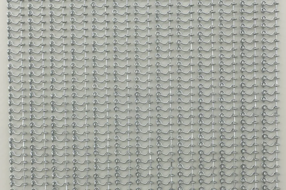 Close view of repeated small metal hooks