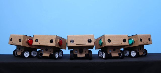 Two BlabDroid robots: small box-shaped wheeled robots with smiling faces